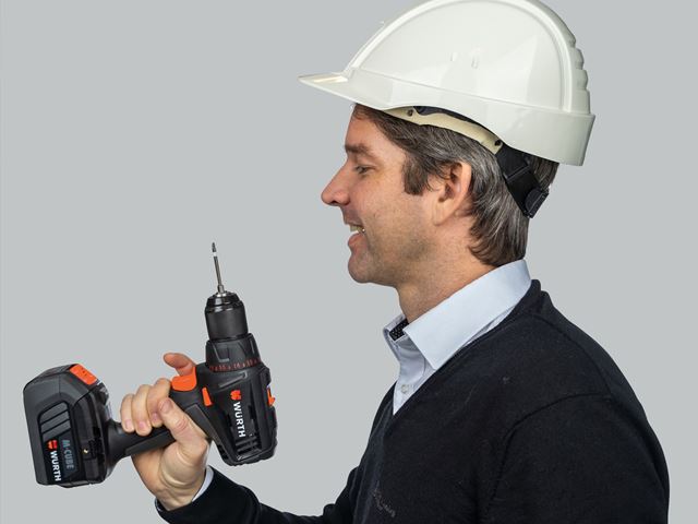 Bankansatt med byggehjelm og drill